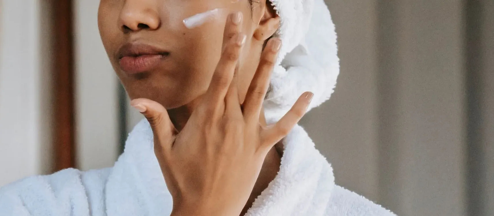 A woman applying a gentle cleanser to her face, showcasing an effective cleansing routine for clear skin.
