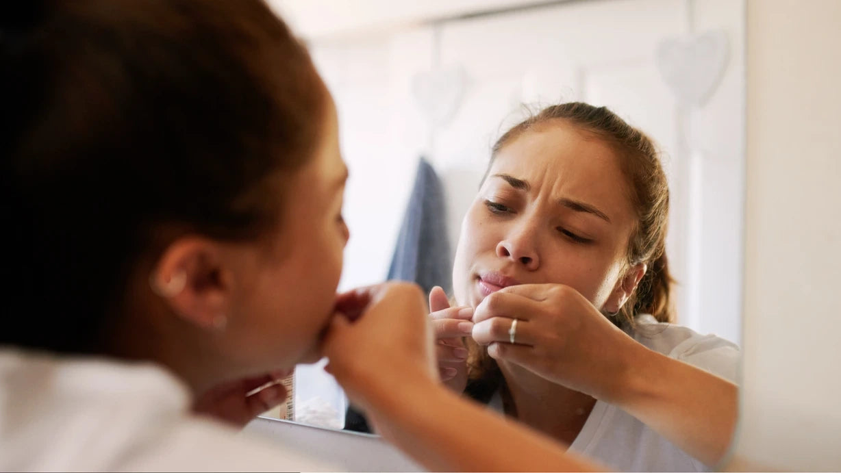 Close-up of a person contemplating the risks of popping pimples, highlighting skin irritation and scarring.