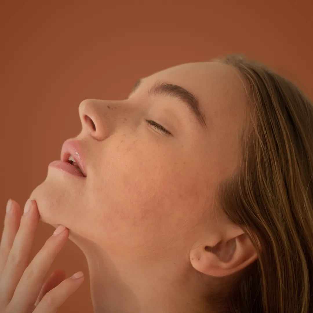 A person applying a bactericidal agent to their skin for clearer complexion and acne treatment.