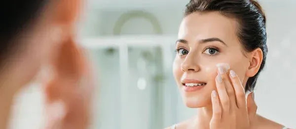 A woman examining skincare products, highlighting items to avoid with ceramide moisturizer.