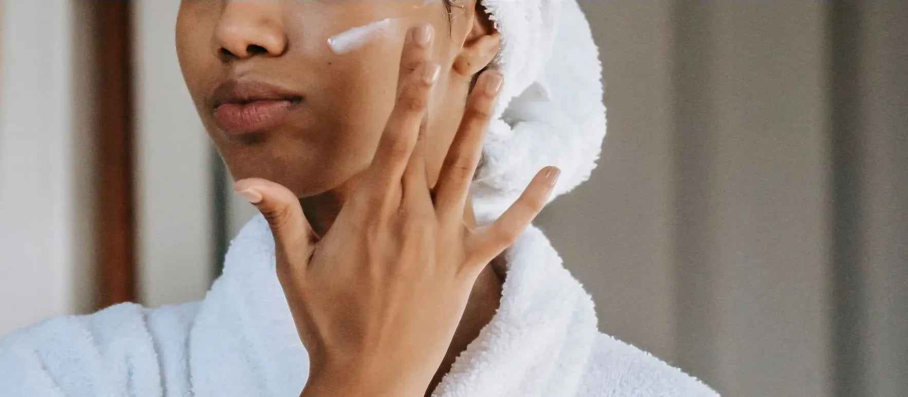 Close-up of a hand applying moisturizer to popped pimples for skin healing and hydration.