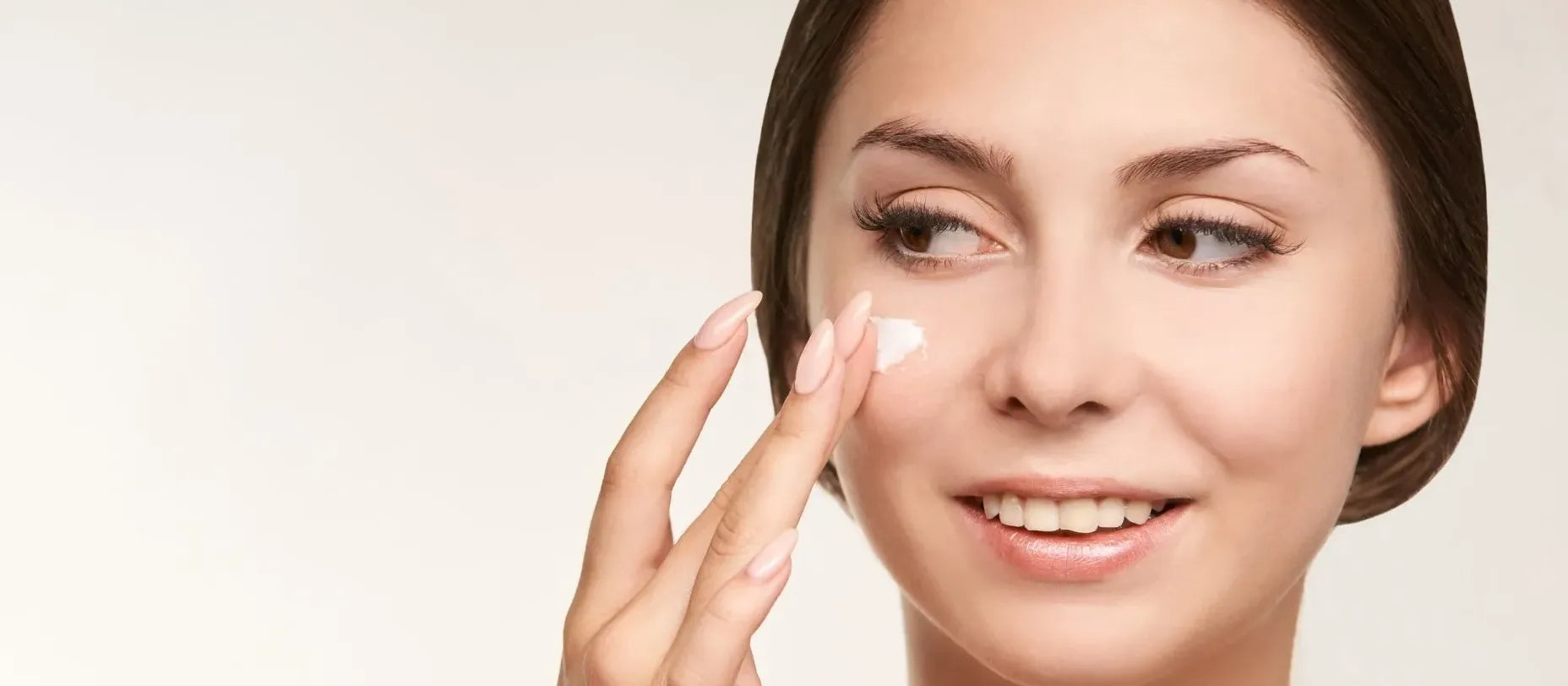 A woman applying AHA and BHA skincare products, exploring daily use for healthy skin.