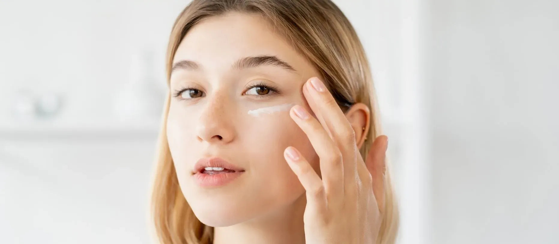 A woman gently cleansing her face with a foamy cleanser, revealing a radiant, glowing complexion.