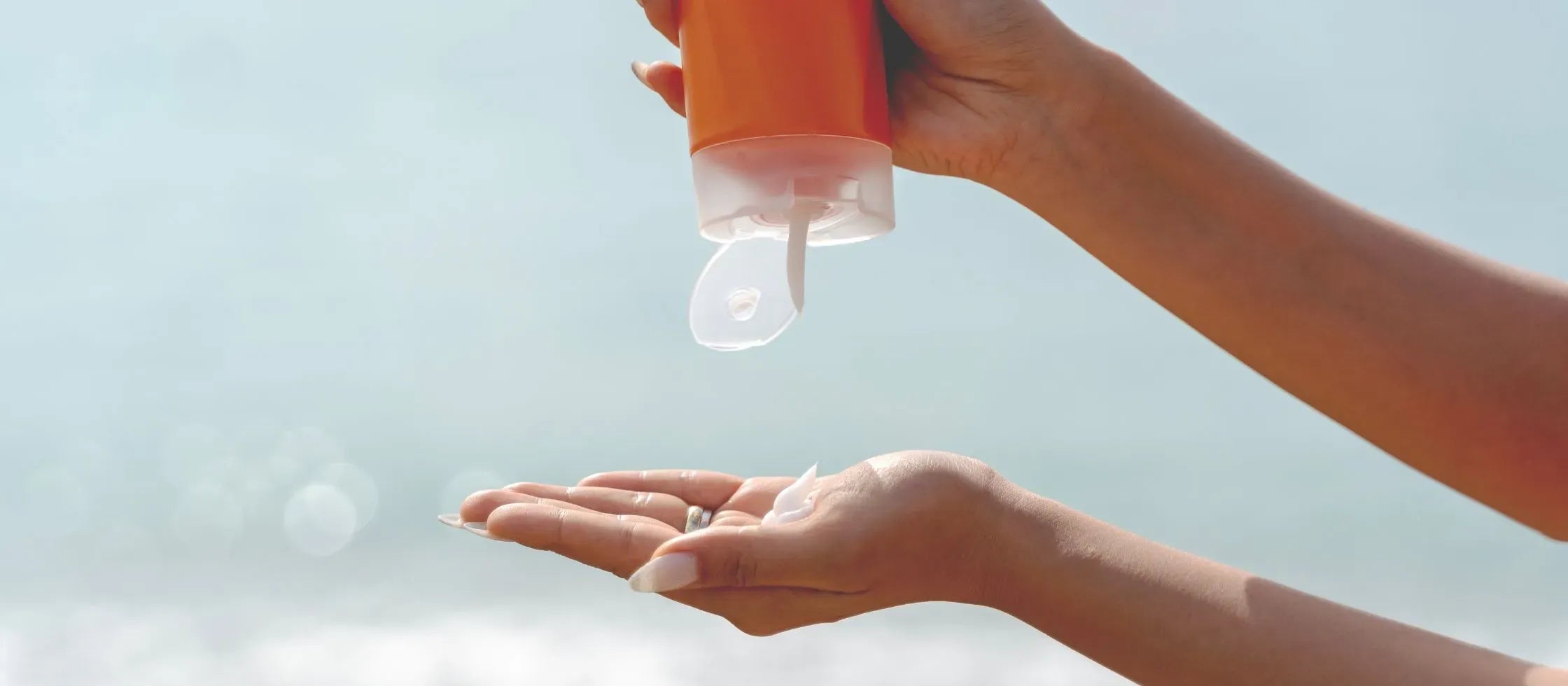 A woman applying moisturizer to her face, showcasing the benefits of radiant skin and hydration.