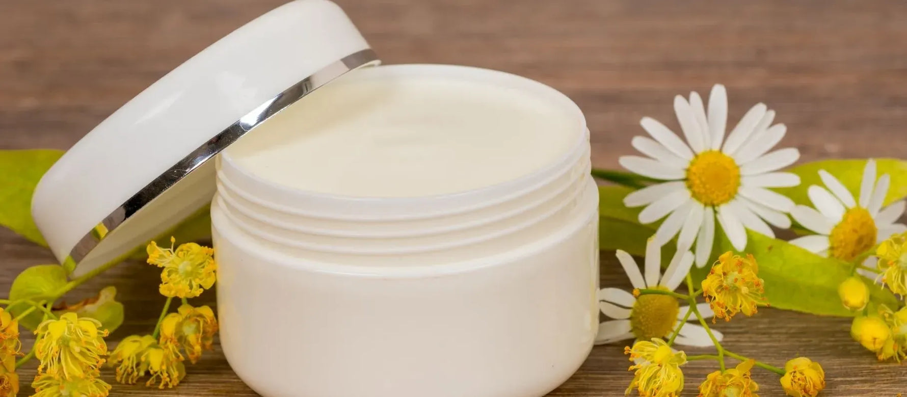 A woman applying acne cream to her face, showcasing her journey to unlock radiant skin.