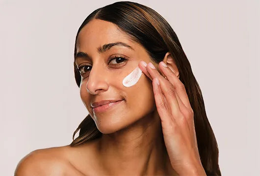 A person applying acne cream on their face, showcasing effective skincare for clear skin.