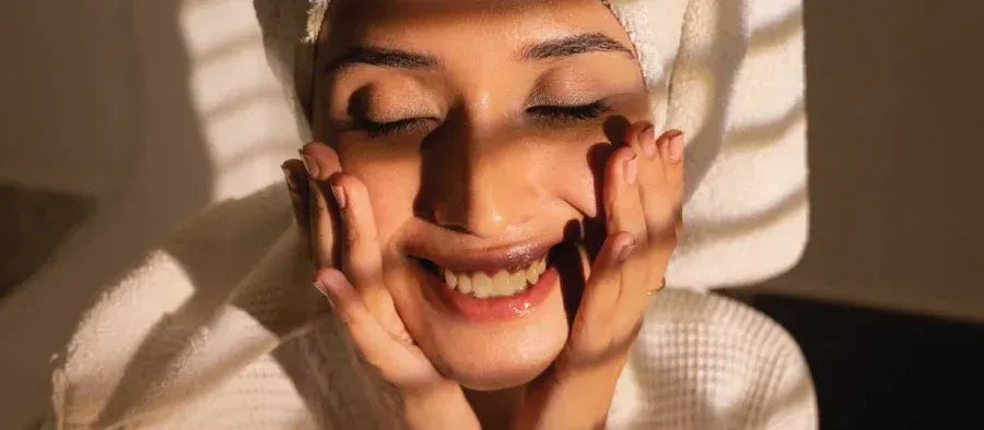 A person applying cleanser to their face, demonstrating effective cleansing techniques for healthy skin.