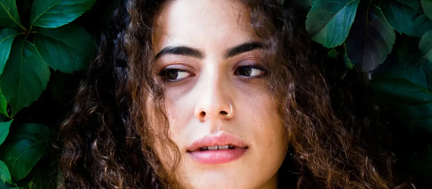 A woman applying a cleansing solution to brighten her skin, showcasing effective skincare techniques.